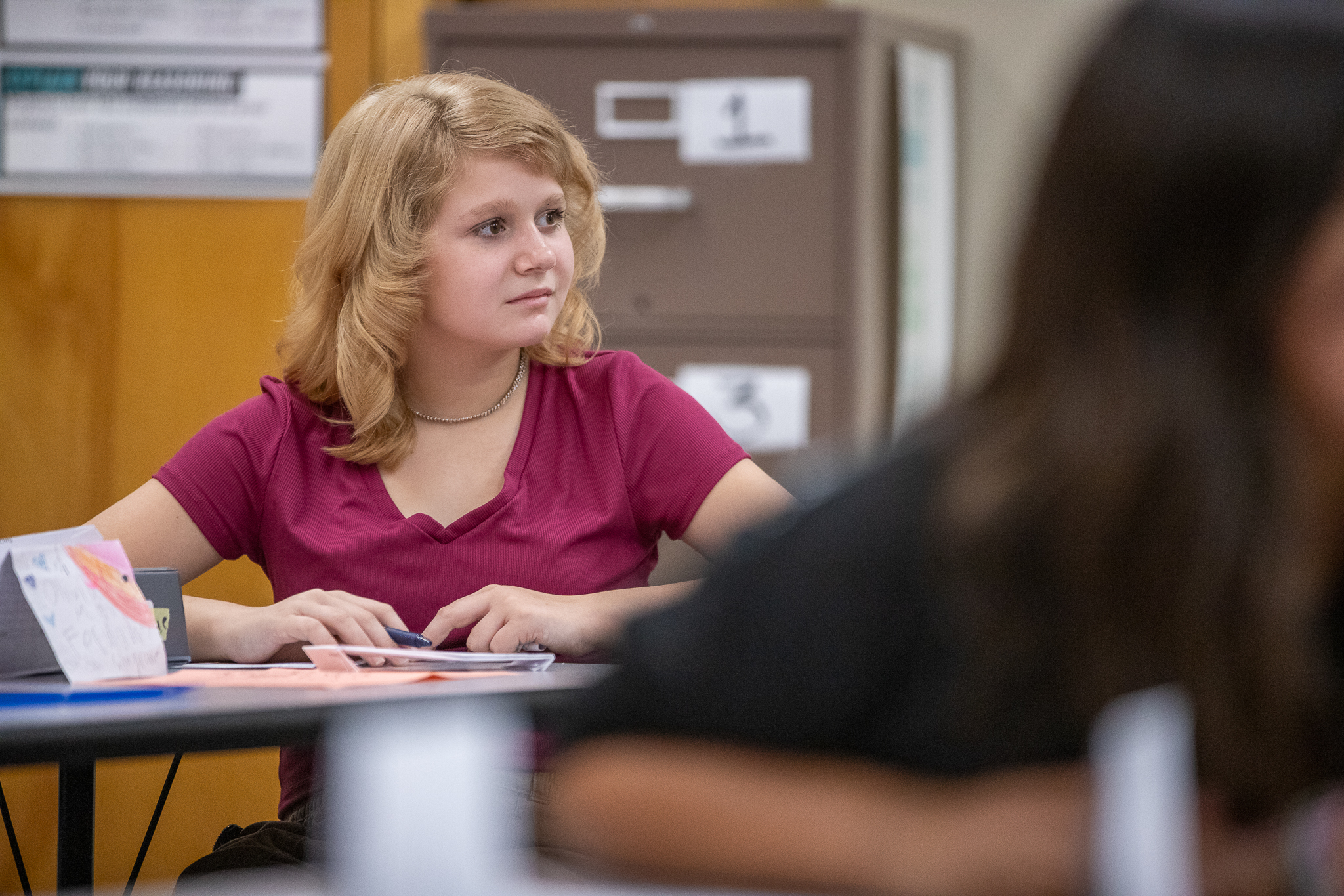 A girl sits at her desk on the first day of school