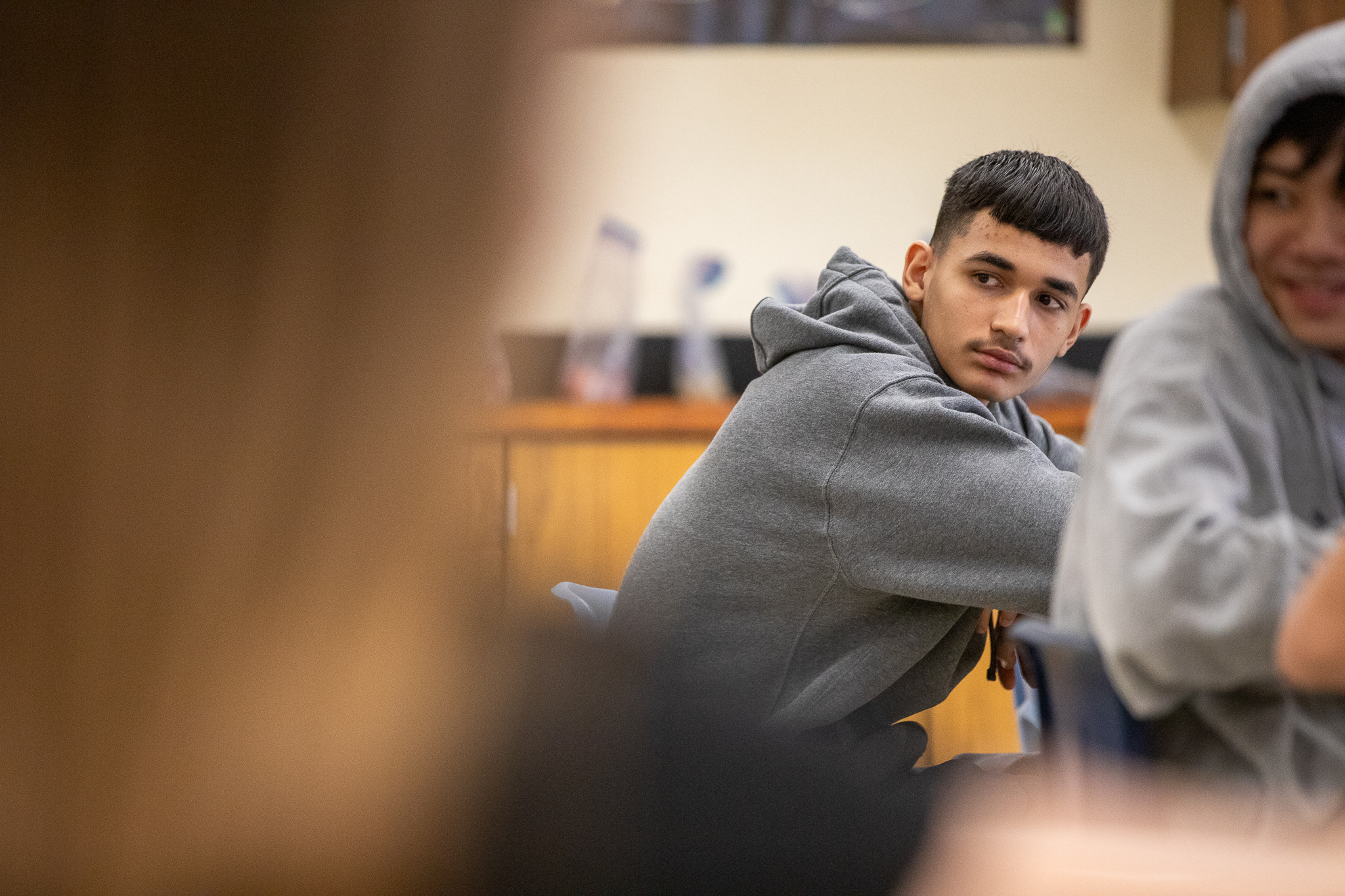 A boy looks over his shoulder at his desk on the first day of school