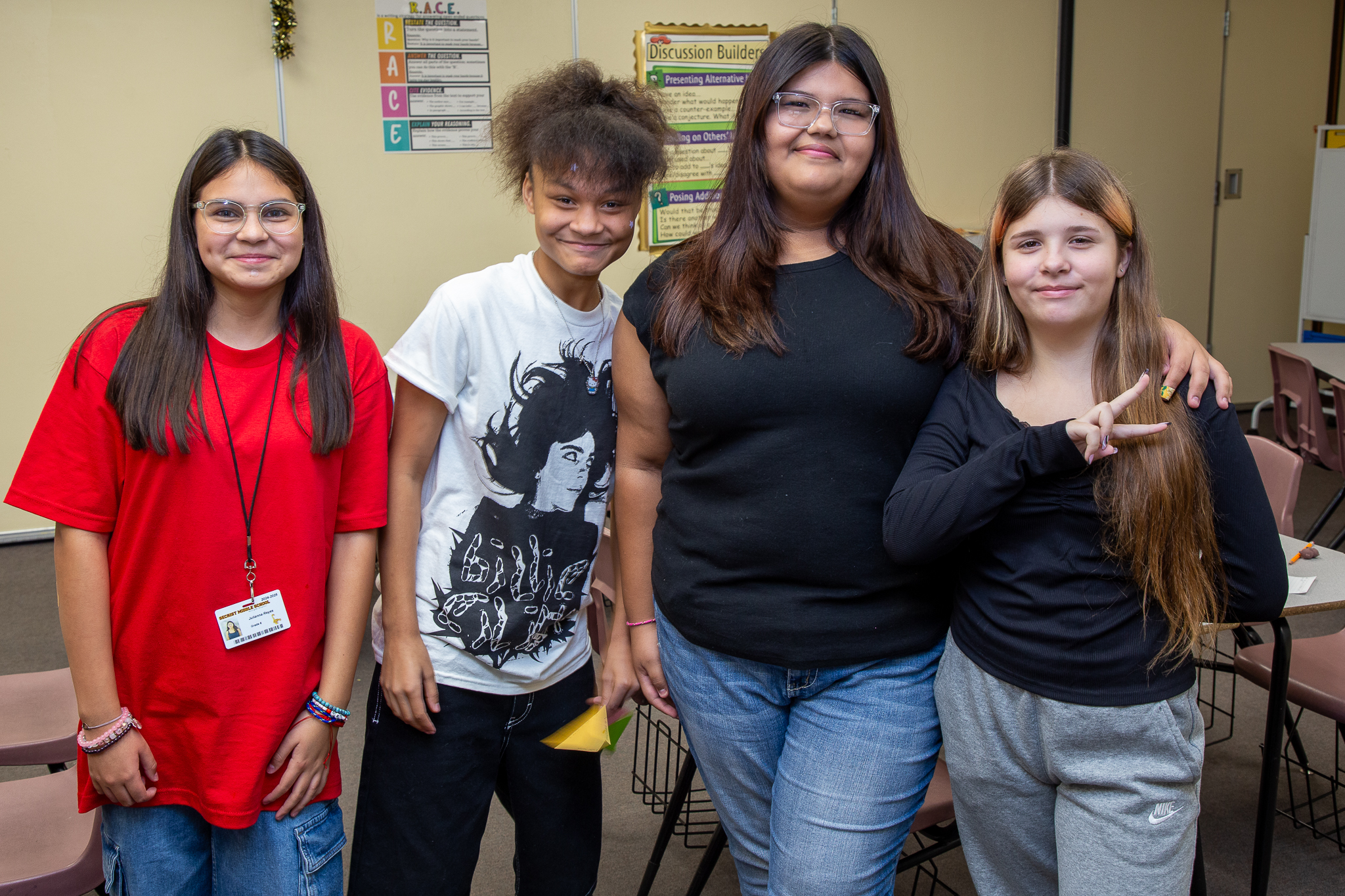 Four girls smile in their classroom on the first day of school