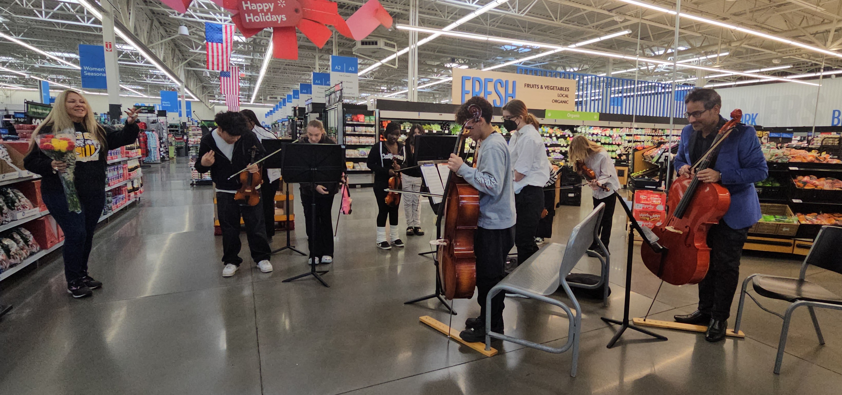 Students perform on their instruments in a Walmart aisle