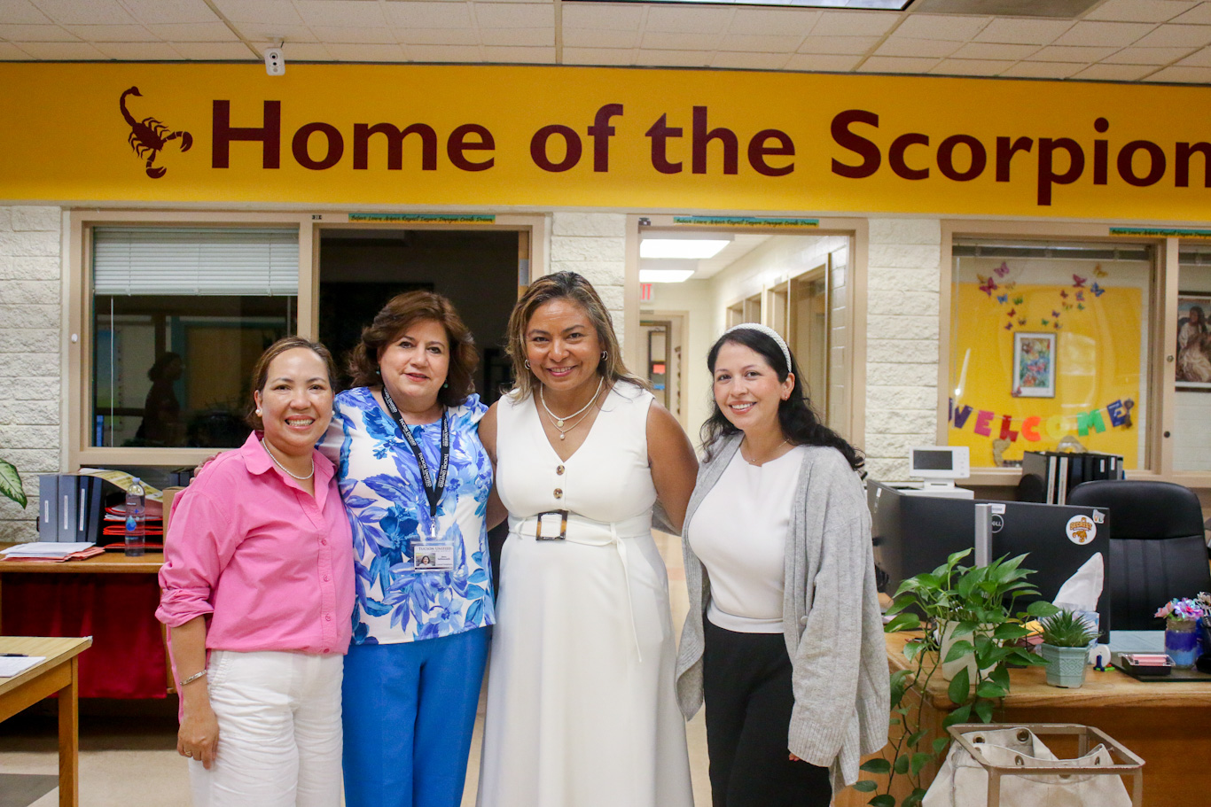 Four women from the front office smile for a group photo